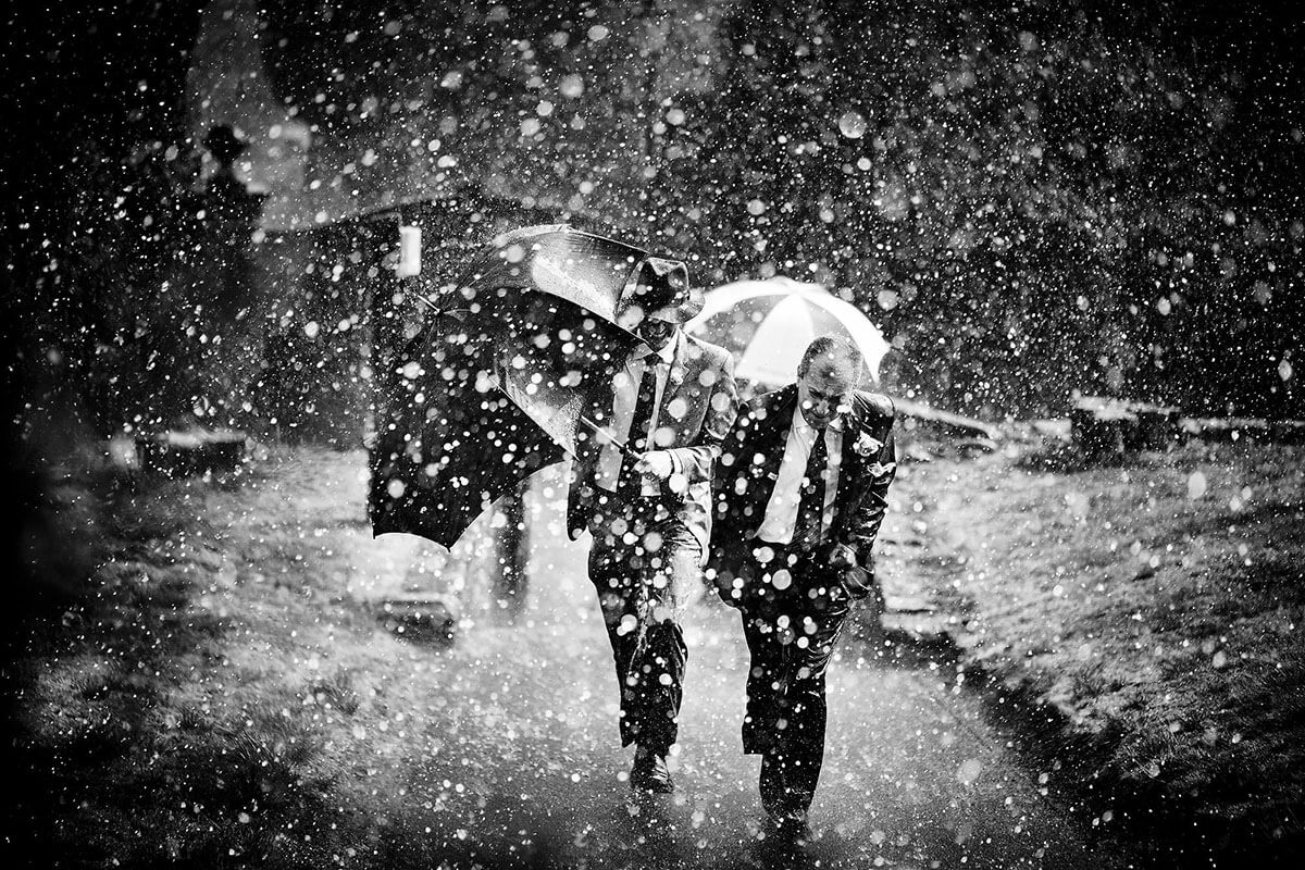 wedding guests arriving at wedding are greeted by the rain