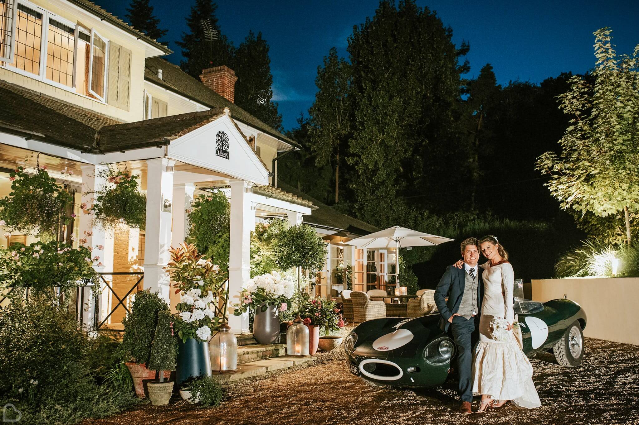a couple poses with their sports car outside russets country house wedding venue