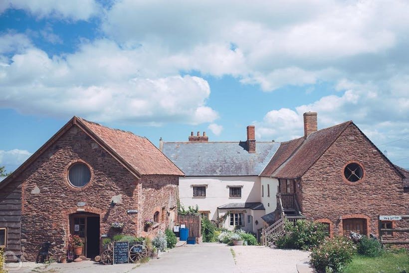 Huntstile Organic Farm with blue skies, a barn and farm wedding venue Somerset
