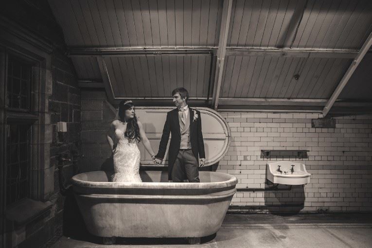 Bridebook.co.uk- bride and groom standing in a bathtub
