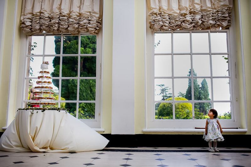 Bridebook.co.uk- flower girl looking up at the cupcake tower