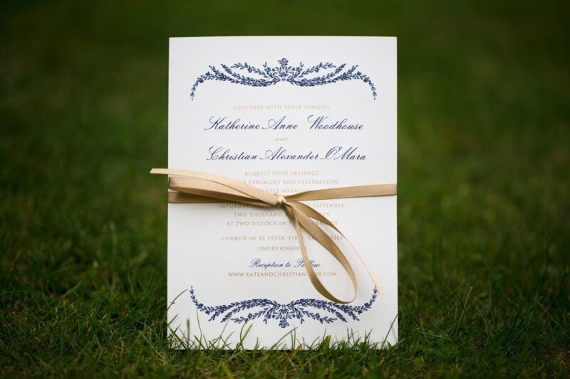 Bridebook.co.uk- wedding invitation sitting on grass tied with yellow ribbon