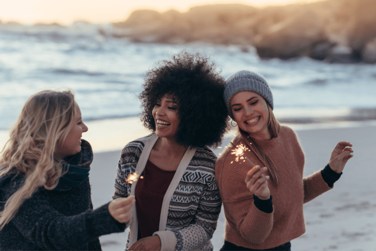 Guests partying on the beach wearing warm clothes