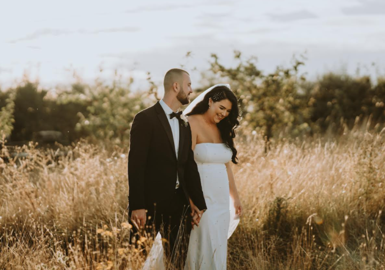 Newlyweds holding hands in a field of wheat