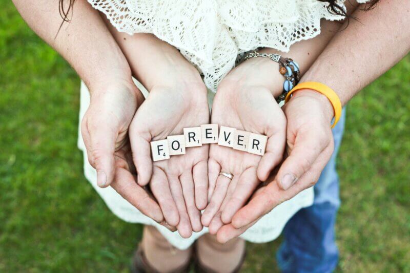 Couple holding Scrabble letter saying forever