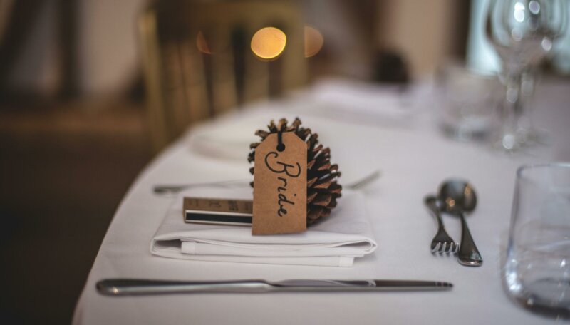 Pine cone with bride name tag on a table