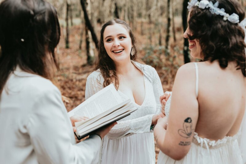 A lady reading at a wedding in the woods