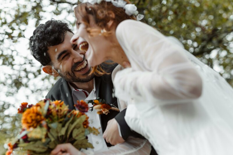 Laughing married couple with bouquet