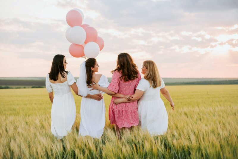 Friends with balloons in a field