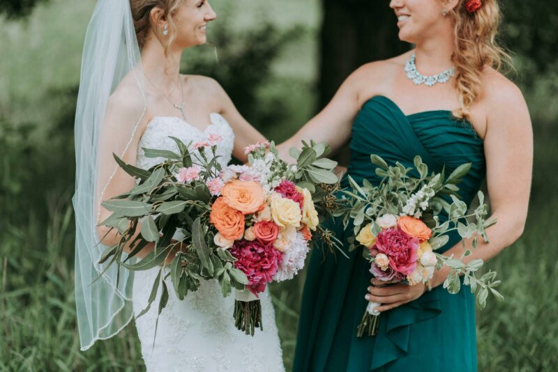 Bride and sister with flower bouquets