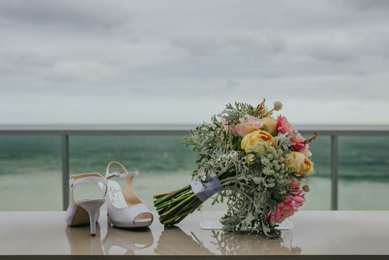 Wedding bouquet with shoes on a sea backdrop