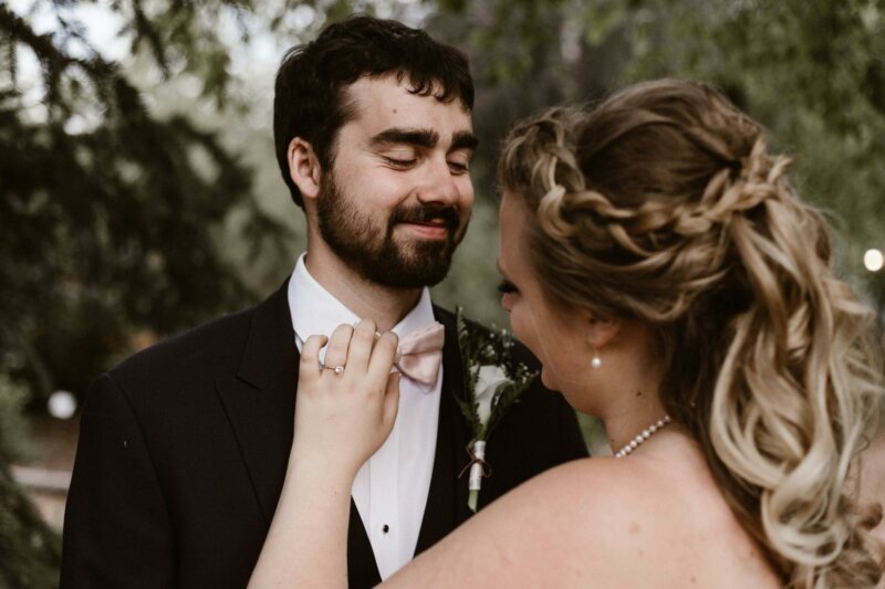 Bride adjusting groom's suit