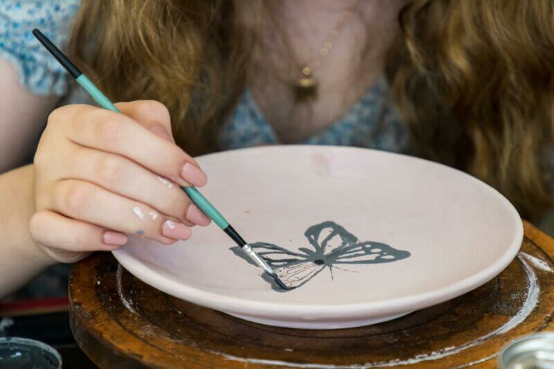 Woman painting a plate