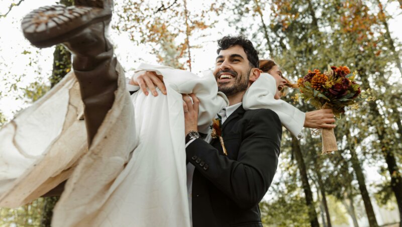 Groom lifting his bride in a forest