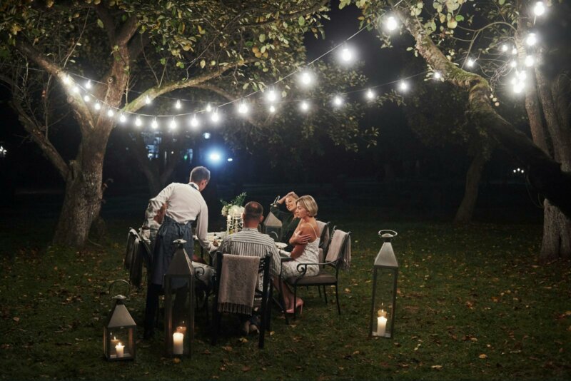 Wedding table under fairylights with a waiter