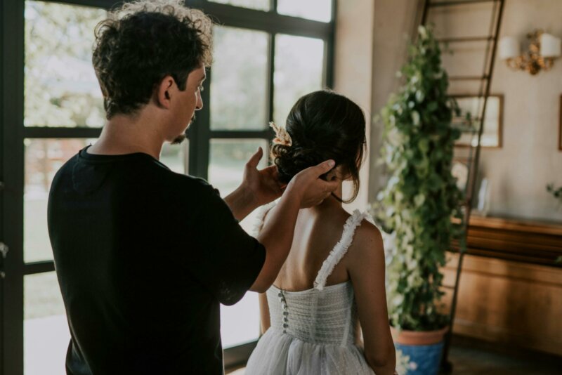 Man arranging a bride's hair