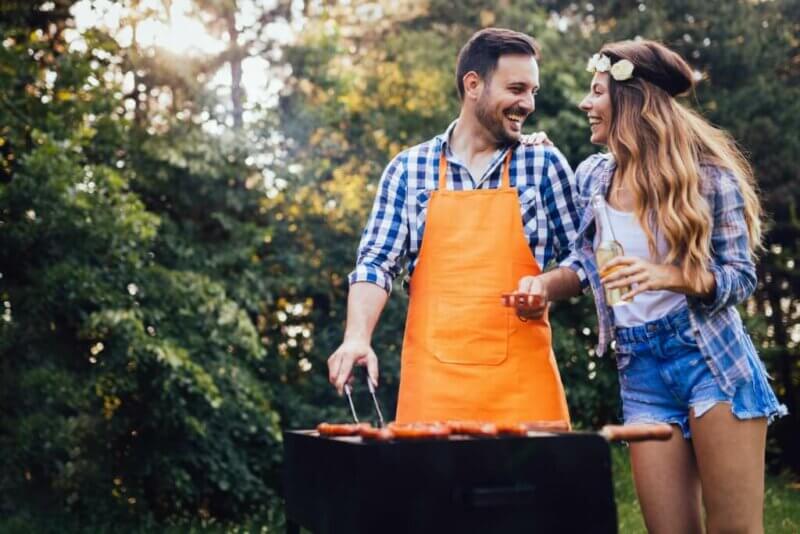 Couple en train de griller de la viande sur un barbecue