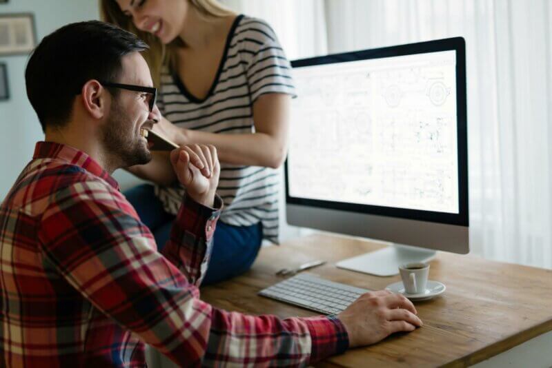 Couple riant devant un ordinateur