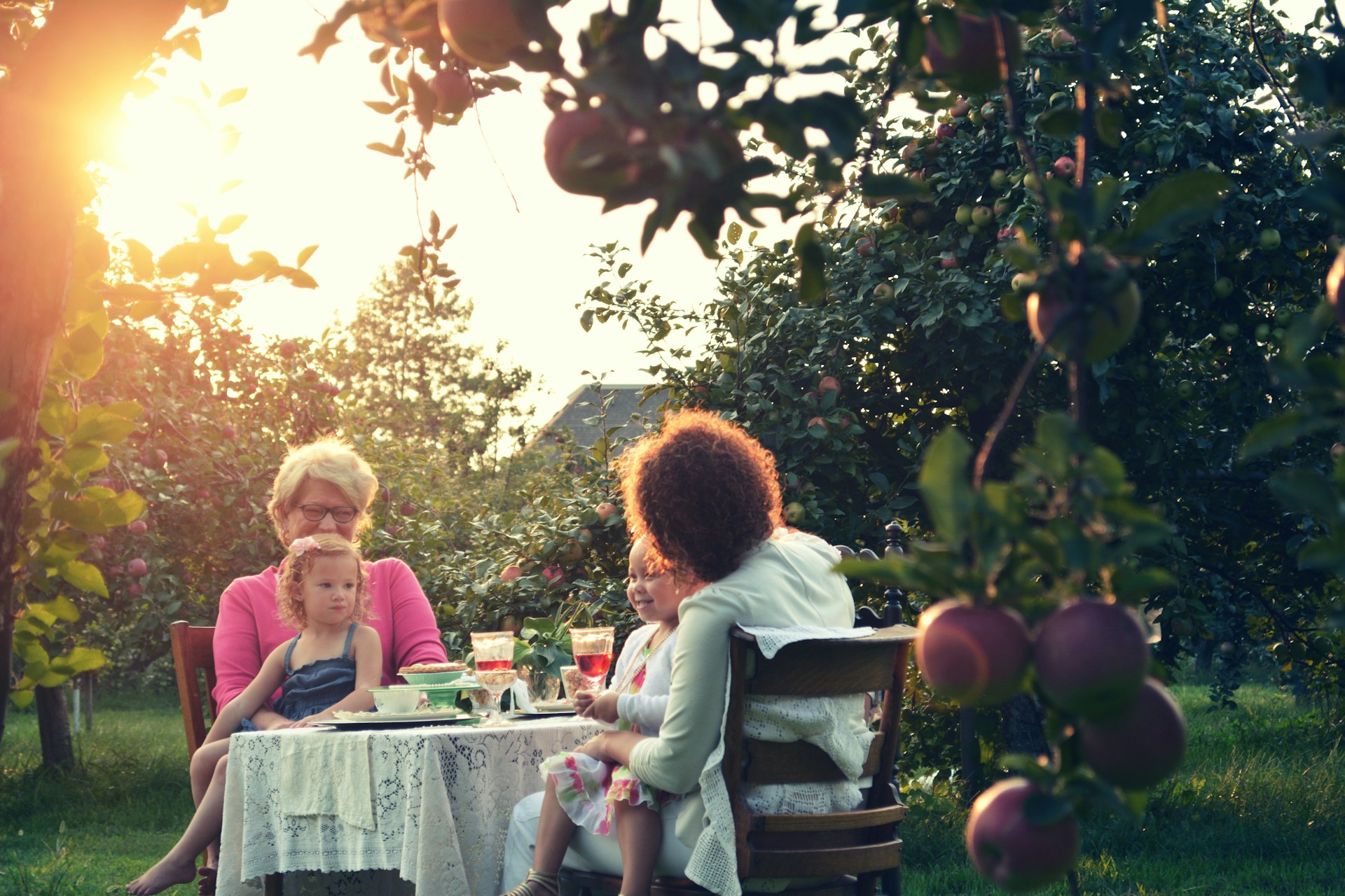 Familie mit Kindern am Tisch im Garten